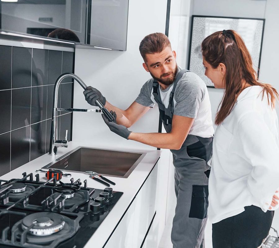 young-professional-plumber-in-grey-uniform-shows-r-resize.jpg